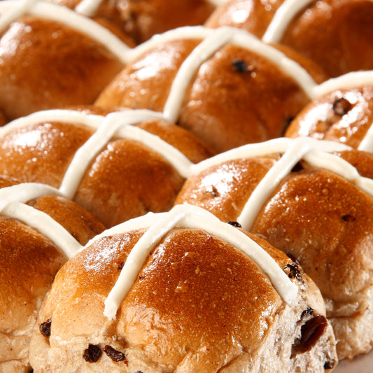 Hot cross buns with cross-shaped icing on a white plate
