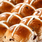 Hot cross buns with cross-shaped icing on a white plate